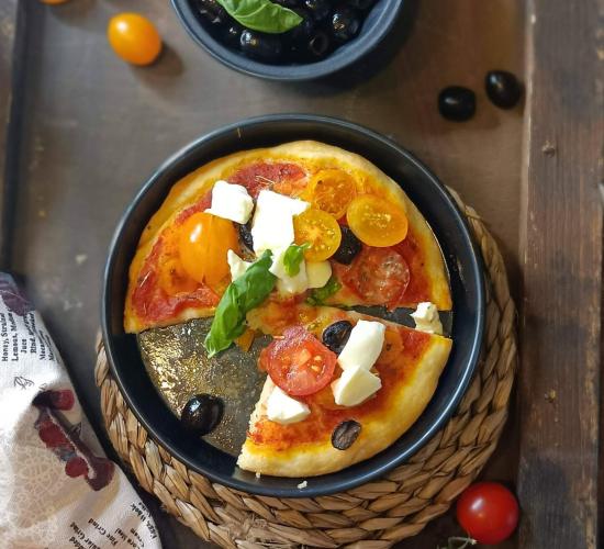Pizza con pomodorini gialli,rossi, mozzarella di bufala e olive nere